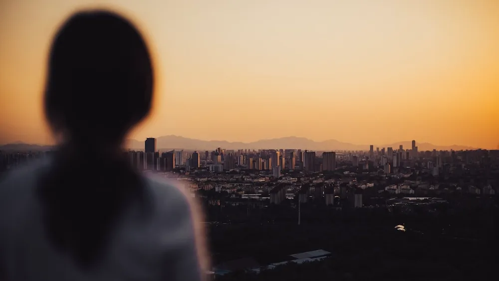 Étudiante face à une nouvelle ville au coucher du soleil